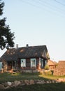 Old wooden house in village. Farmhouse in Belarus. View of rustic ethnic house on sunset. rural landscape Royalty Free Stock Photo