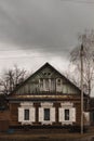 Old wooden house with white shutters in cloudy weather