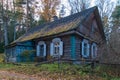 An old wooden house with white window shutters in the fall Royalty Free Stock Photo