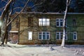 Old wooden house in the winter at night. Glowing window with a cat on the window Royalty Free Stock Photo