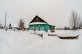 Old wooden house in the winter village, snow drifts