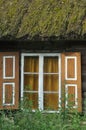 Old wooden house with wooden shutters and thatched roof. Rural buildings. Royalty Free Stock Photo