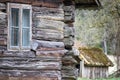 old wooden house with wooden window pane and dog house in the background Royalty Free Stock Photo