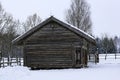 An old wooden hut. Abandoned Russian village covered in snow. Log house with a barn with a wooden wicker fence. Royalty Free Stock Photo