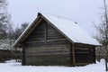 An old wooden hut. Abandoned Russian village covered in snow. Log house with a barn with a wooden wicker fence. Royalty Free Stock Photo