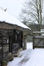 An old wooden hut. Abandoned Russian village covered in snow. Log house with a barn with a wooden wicker fence. Royalty Free Stock Photo