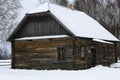 An old wooden hut. Abandoned Russian village covered in snow. Log house with a barn with a wooden wicker fence. Royalty Free Stock Photo