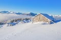 Old wooden hut covered by snow.