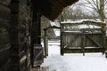 A log house with a thatched roof. Courtyard with wooden fence and old gate. Royalty Free Stock Photo