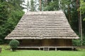 Old wooden hut with straw roof in forest on summer day Royalty Free Stock Photo