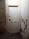 Old wooden interior door, locked, in dark corridor in abandoned old house.