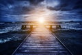Old wooden jetty during storm on the ocean. Abstract light Royalty Free Stock Photo