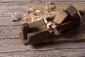 Old wooden jointer, boards and shavings close-up on wooden background. Royalty Free Stock Photo