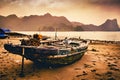 Old wooden junk boat on a beach on Cat Ba Island with ha long bay hills and sunset in the background. Catba, Vietnam Royalty Free Stock Photo