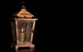 Old wooden lantern with a burning candle isolated on black background. Royalty Free Stock Photo