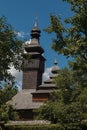 Old wooden Lemk church against a bright blue sky with clouds. Royalty Free Stock Photo