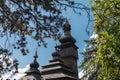 Old wooden Lemk church against a bright blue sky with clouds. Royalty Free Stock Photo