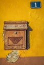 Old wooden letterbox on a yellow wall