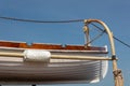 Old wooden lifeboat hoisted up on the side of an old tall ship, rigging details