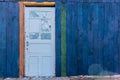 Old wooden light blue door in a dark blue wall Royalty Free Stock Photo