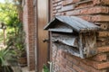 Old wooden mailbox by brick house front door Royalty Free Stock Photo