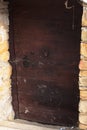 Old wooden massive cellar door on historical house, covered with cobwebs. Royalty Free Stock Photo