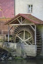 An old wooden mill wheel on an old building on the edge of a river Royalty Free Stock Photo