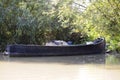 An old wooden motorboat loaded with empty fishnets left by poacherson the river