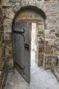 An old wooden open entrance door in the opening with an arch in a stone castle Royalty Free Stock Photo