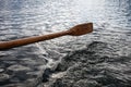 Old wooden paddle over water Royalty Free Stock Photo