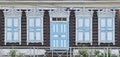 Old wooden painted white blue windows, door. Carved architraves, closed shutters. Ulan-Ude, Russia. Royalty Free Stock Photo