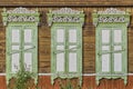 Old wooden painted white green windows, door. Carved architraves, closed shutters. Ulan-Ude, Russia. Royalty Free Stock Photo