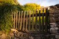 Old wooden picket fence built into a wall from stones. Royalty Free Stock Photo
