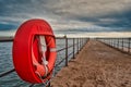 The old wooden pier at Blyth in Northumberland with lifebuoy ring on the left side. Blyth lighthouse in the background. Royalty Free Stock Photo