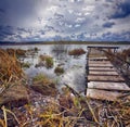 Old wooden pier with dry reed Royalty Free Stock Photo