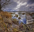 Old wooden pier with dry reed Royalty Free Stock Photo