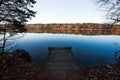 Old wooden pier for fishing in autumn forest lake Royalty Free Stock Photo