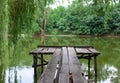 Old wooden pier on the lake on the background of the forest. Summer warm evening Royalty Free Stock Photo