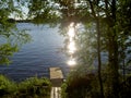 Old wooden pier by a lake in shady woods Royalty Free Stock Photo