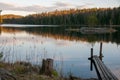 The old wooden pier on a lake in spring forest. Trees and sky reflected in the calm waters of a forest lake.  Natural background. Royalty Free Stock Photo