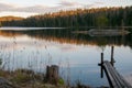 The old wooden pier on a lake in spring forest. Trees and sky reflected in the calm waters of a forest lake.  Natural background. Royalty Free Stock Photo