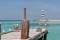 Old wooden pier and red and white lighthouse Royalty Free Stock Photo