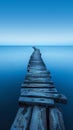 Old wooden pier stretching into a serene blue sea at twilight