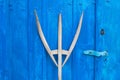 old wooden pitchfork leaning on blue barn door Royalty Free Stock Photo