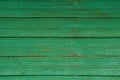 Old wooden planks with bright green paint cracked and faded in the sun. Wood texture Royalty Free Stock Photo