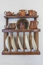 Old wooden plate rack full of pottery