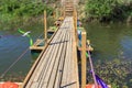 Old wooden pontoon bridge with rope rails on a small quiet river Royalty Free Stock Photo