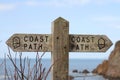 Old wooden public footpath sign overlooking Hope Cove in Devon, United Kingdom Royalty Free Stock Photo