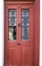 Old wooden red door with black wrought details