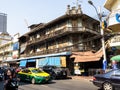 Old wooden residential building the midst of the busy street traffic in Bangkok, Thailand